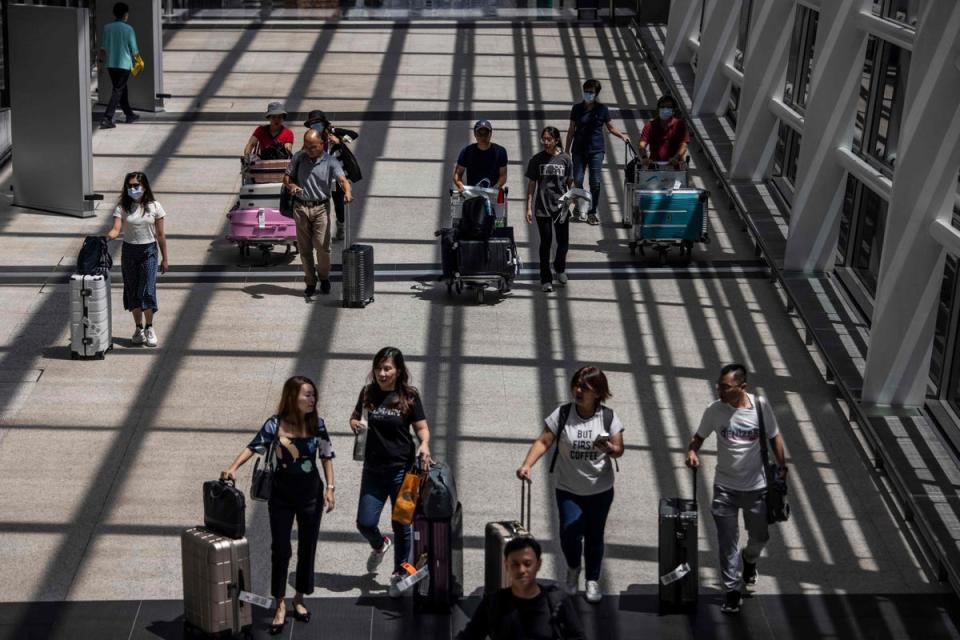 Passengers walk through Hong Kong International Airport on July 6, 2023. (AFP via Getty Images)