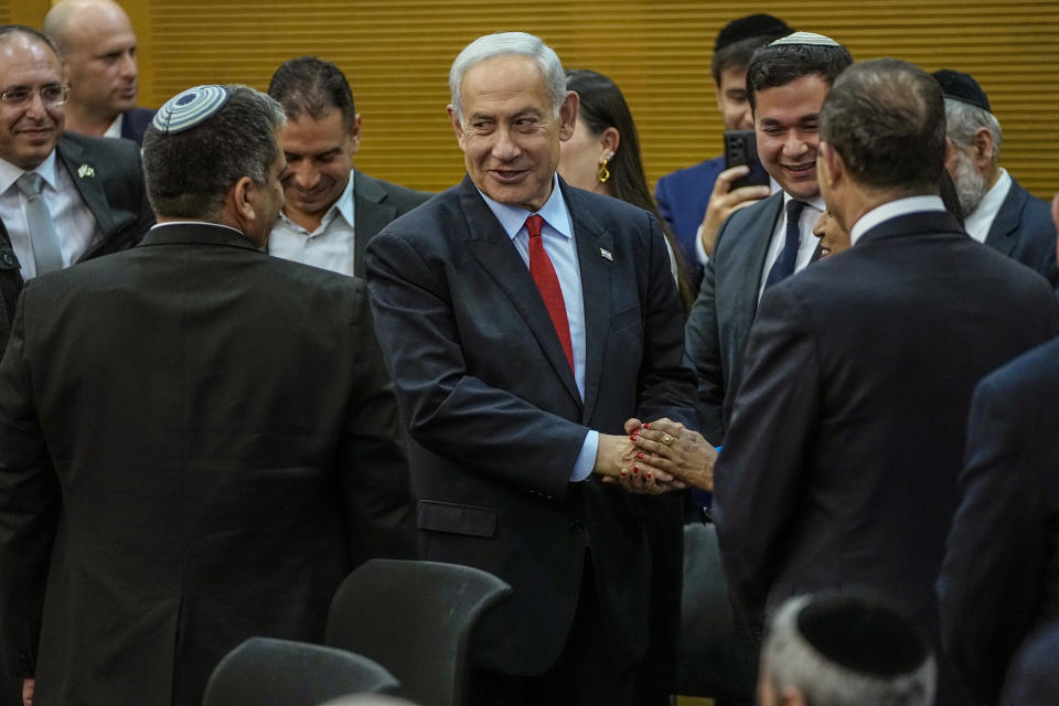 Israeli Prime Minister Benjamin Netanyahu is greeted before delivering a statement in the Knesset, Israel's parliament in Jerusalem, Tuesday, May 23, 2023. (AP Photo/Ohad Zwigenberg)