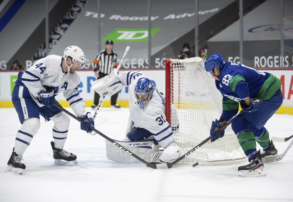 Toronto Maple Leafs goalie Frederik Andersen (31), of Denmark, stops Vancouver Canucks' Jay Beagle (83) as Toronto's Morgan Rielly (44) defends during the second period of an NHL hockey game in Vancouver, British Columbia, on Saturday, March 6, 2021. (Darryl Dyck/The Canadian Press via AP)