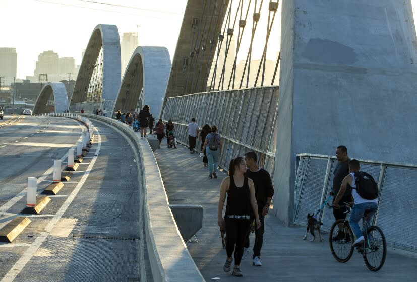 Los Angeles, CA - July 27: Pedestrians walk across the new 6th Street Bridge, which has been closed intermittently since opening due to street racing and other illegal activity on Wednesday, July 27, 2022 in Los Angeles, CA. (Brian van der Brug / Los Angeles Times)