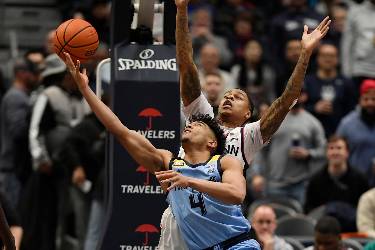 Marquette guard Stevie Mitchell puts up a shot underneath the basket against UConn guardJordan Hawkins during the first half Tuesday night.