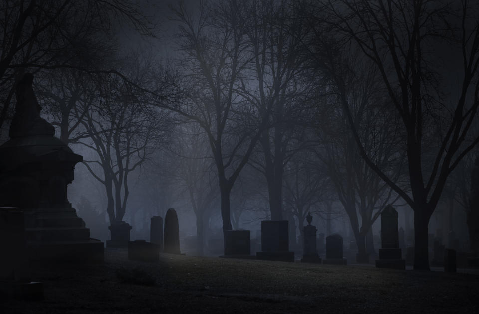 Spooky cemetery at night with fog