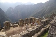 Maintenance workers clean the empty Machu Picchu archeological site that's closed to the public amid the COVID-19 pandemic in the department of Cusco, Peru, Tuesday, Oct. 27, 2020. The world-renown Incan citadel of Machu Picchu will reopen to the public on Nov. 1. (AP Photo/Martin Mejia)