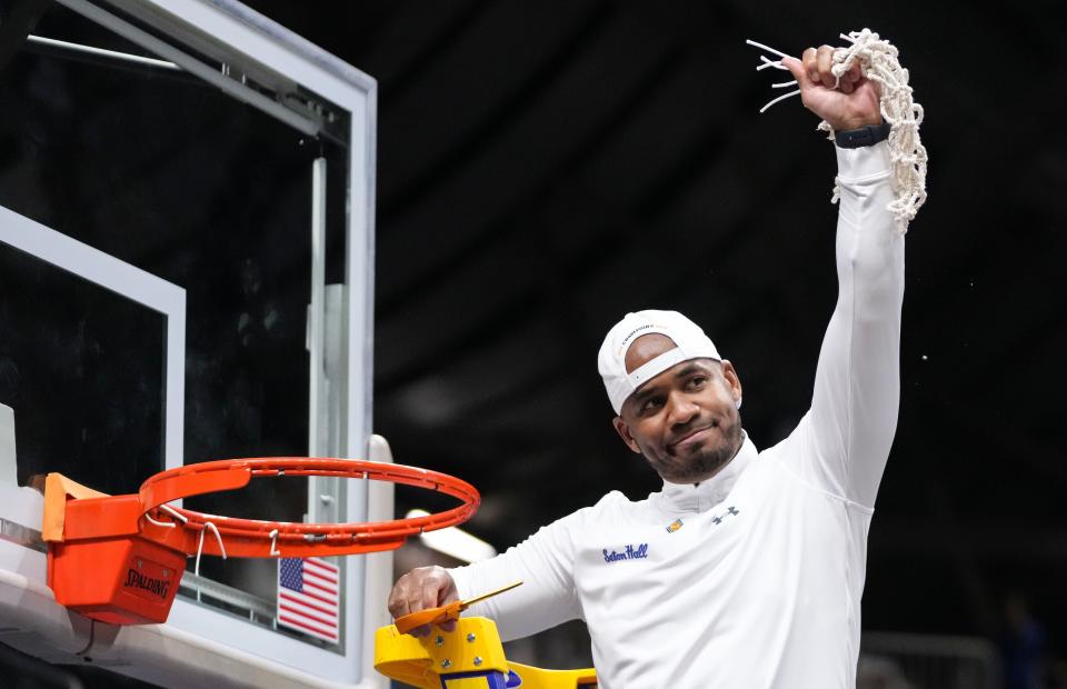 Seton Hall Pirates head coach Shaheen Holloway holds up the net Thursday, April 4, 2024, during the NIT championship game at Hinkle Fieldhouse in Indianapolis. The Seton Hall Pirates defeated the Indiana State Sycamores, 79-77.