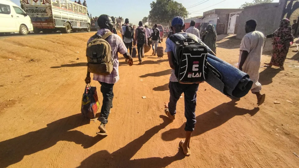 PHOTO: People displaced by the conflict in Sudan walk with their belonging along a road in Wad Madani, the capital of al-Jazirah state, on Dec. 16, 2023.  (AFP via Getty Images)