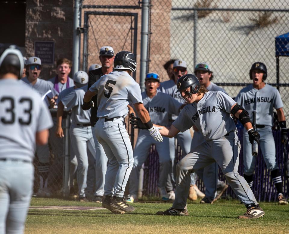 Peninsula's Jack Gold (5) celebrates a run to tie the game in the sixth with teammate Reed Woodland (8) during their CIF-SS semifinal game at Shadow Hills High School in Indio, Calif., Tuesday, May 16, 2023. 
