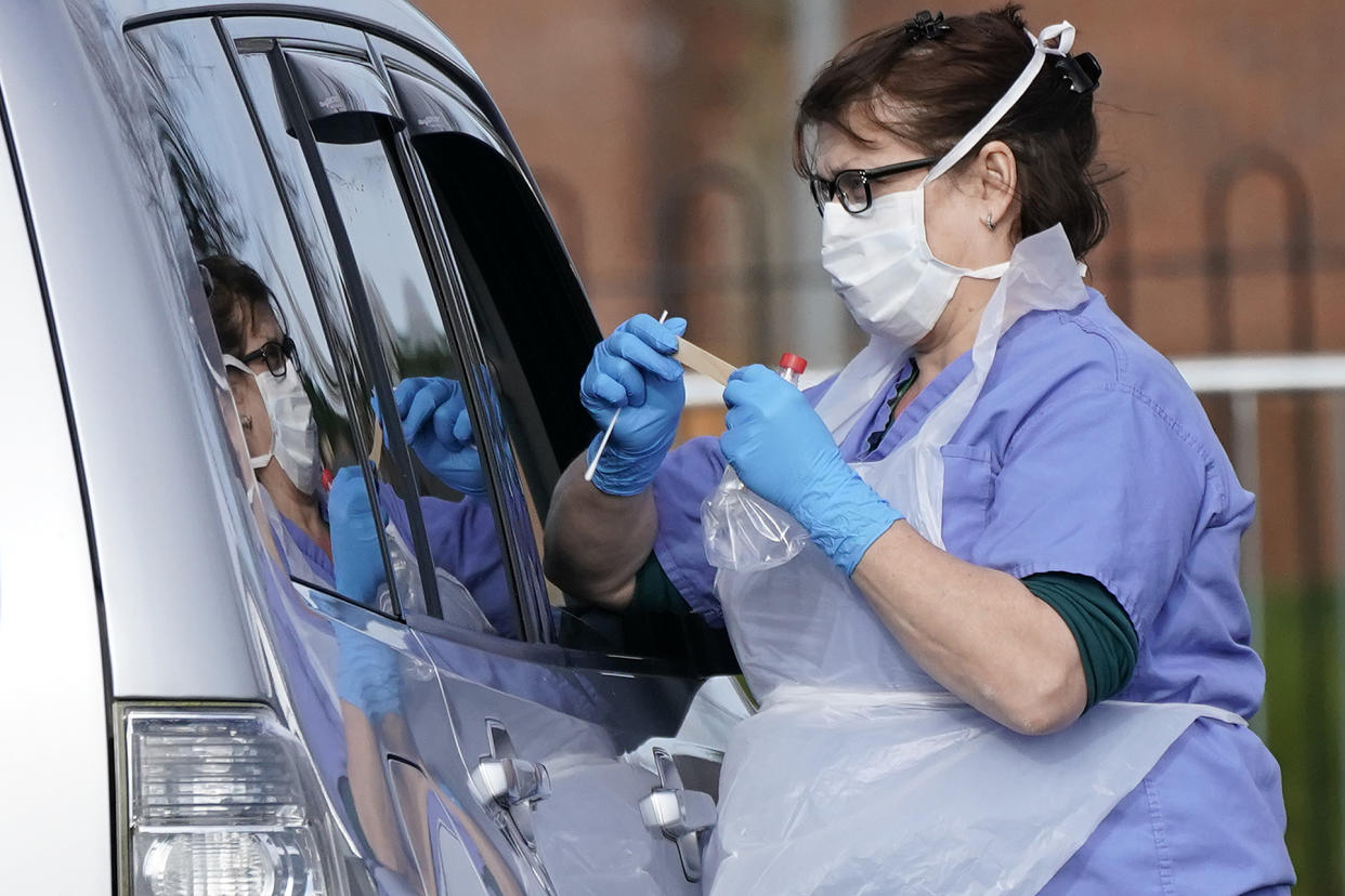 WOLVERHAMPTON, ENGLAND - MARCH 12:  A member of the public is swabbed at a drive through Coronavirus testing site, set up in a car park, on March 12, 2020 in Wolverhampton, England. The National Health Service facility has been set up in a car park to allow people with NHS referrals to be swabbed for Covid-19.  (Photo by Christopher Furlong/Getty Images)