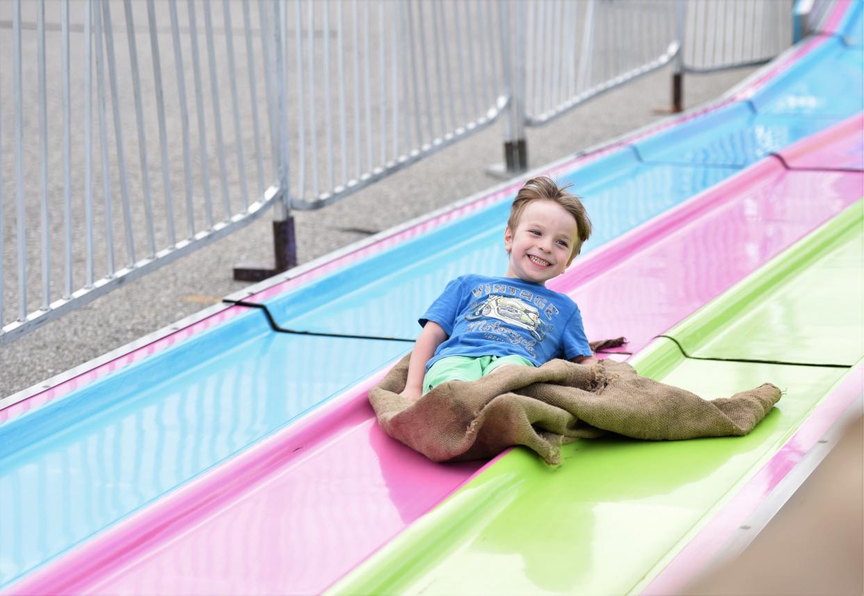 Mason McGuire, 5, smiles as he cruises down a slide on Thursday, July 2023, at the Blue Water Fest carnival during Family Night. Via Family Fun Tyme Amusements, the carnival will run from noon to 10 p.m. Friday and Saturday.