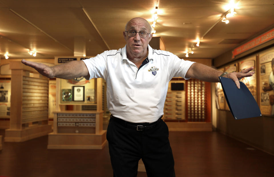 Dennis Schrader gestures as he tells a story after cutting the ribbon to open his exhibit of autographed baseballs Tuesday, Oct. 22, 2013, at the St. Petersburg Museum of History in St. Petersburg, Fla. New York Yankees legend Mickey Mantle signed a baseball for Schrader in 1956, when Schrader was a 9-year-old boy attending a spring training game in Florida, leading to a lifelong obsession: He now has more than 4,600 signed baseballs, certified by Guinness as the largest such collection in the world. (AP Photo/Chris O'Meara)