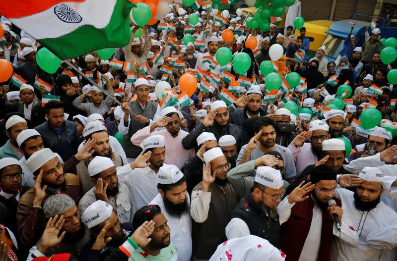 Demonstrators salute during Republic Day celebrations at the site of a protest against a new citizenship law in Ahmedabad