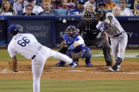 Colorado Rockies' Brendan Rodgers, right, hits a single as Los Angeles Dodgers starting pitcher Mitch White, left, watches along with catcher Austin Barnes, second from left, and home plate umpire Chris Segal during the sixth inning of a baseball game Wednesday, July 6, 2022, in Los Angeles. (AP Photo/Mark J. Terrill)