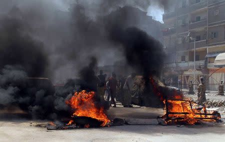 Protesters, supporters of the Muslim Brotherhood, are seen behind burning tires during a protest in the Matariya area in Cairo, August 14, 2014. REUTERS/Al Youm Al Saabi Newspaper