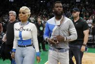 Rapper Gucci Mane and his wife, Keyshia Ka'Oir, walk off the court at halftime while attending Game 3 of a second-round NBA basketball playoff series between the Boston Celtics and the Milwaukee Bucks in Boston, Friday, May 3, 2019. (AP Photo/Michael Dwyer)