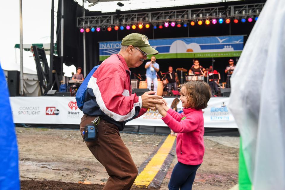 Juan Perez and 6-year-old Mia Paxson dance to the music of Orquesta SCC at the National Folk Festival in Salisbury on Saturday, Sept. 8.