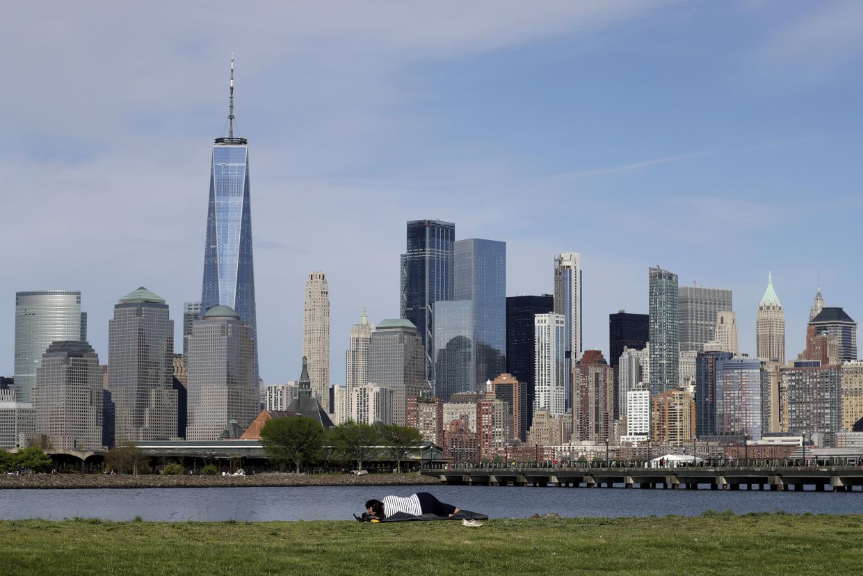 A woman looks at the Manhattan skyline from Liberty State Park in Jersey City, N.J. on Saturday, May 2, 2020. Gov. Phil Murphy said early reports of behavior at New Jersey's just-reopened parks and golf courses were "so far so good" with people adhering to social distancing. Murphy earlier said state troopers and park police would closely watch parks and golf courses as they reopened during especially fine weather over the weekend.