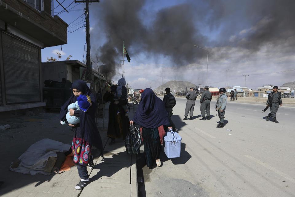 An Afghan family escapes the area of a suicide bombing in Kabul, Afghanistan, Wednesday, March 1, 2017. Near-simultaneous attacks by Taliban suicide bombers have struck the Afghan capital, killing several people and wounding at least 50. (AP Photo/Rahmat Gul)