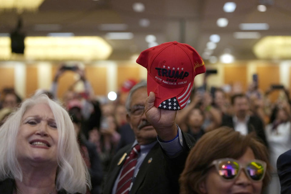 A man holds a Donald Trump hat as the former president speaks at the California Republican Party Convention Friday, Sept. 29, 2023, in Anaheim, Calif. (AP Photo/Jae C. Hong)