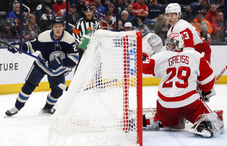 Columbus Blue Jackets defenseman Adam Boqvist, left, watches his goal against Detroit Red Wings goalie Thomas Greiss, center, and defenseman Moritz Seider during the second period of an NHL hockey game in Columbus, Ohio, Monday, Nov. 15, 2021. (AP Photo/Paul Vernon)