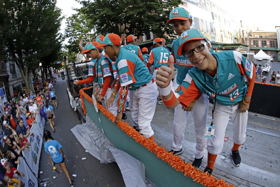 Members of the Latin America Region Champion Little League team from Maracaibo, Venezuela, ride in the Little League Grand Slam Parade in downtown Williamsport, Pa., Wednesday, Aug. 14, 2019. The Little League World Series baseball tournament, featuring 16 teams from around the world, starts Thursday in South Williamsport. (AP Photo/Gene J. Puskar)