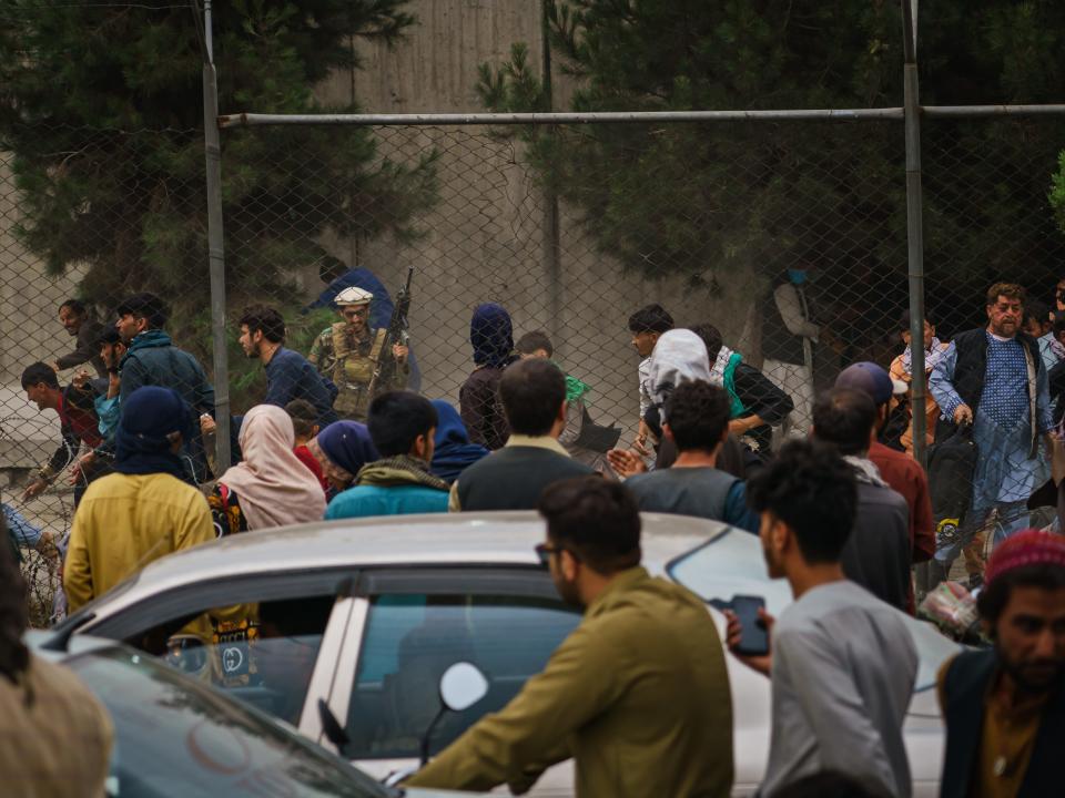 Taliban fighters use guns fire, whips, sticks and sharp objects to maintain crowd control on airport road in Kabul, Afghanistan