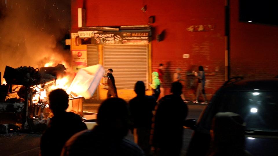 A man throws an item onto a fire during unrest in Harehills, Leeds (Ã’@robin_singhÃ“ via REUTERS)