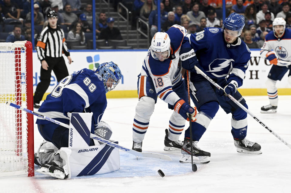 Tampa Bay Lightning goaltender Andrei Vasilevskiy (88) makes a save as Edmonton Oilers left wing Zach Hyman (18) looks for a shot during the third period of an NHL hockey game Tuesday, Nov. 8, 2022, in Tampa, Fla. (AP Photo/Jason Behnken)