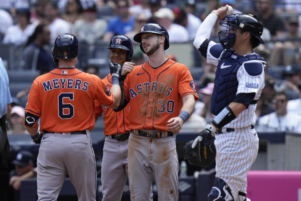 New York Yankees catcher Kyle Higashioka, right, looks on as Houston Astros' Kyle Tucker (30), second from right, Jeremy Pena, second from left, greet Jake Meyers after he hit a three-run homer during the second inning of the baseball game at Yankee Stadium, Sunday, Aug. 6, 2023, in New York. (AP Photo/Seth Wenig)