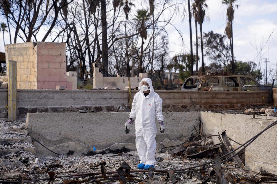 Rev. Ai Hironaka, resident minister of the Lahaina Hongwanji Mission, stands in the grounds of his temple destroyed by wildfire, Thursday, Dec. 7, 2023, in Lahaina, Hawaii. Recovery efforts continue after the August wildfire that swept through the Lahaina community on Hawaiian island of Maui, the deadliest U.S. wildfire in more than a century. (AP Photo/Lindsey Wasson)