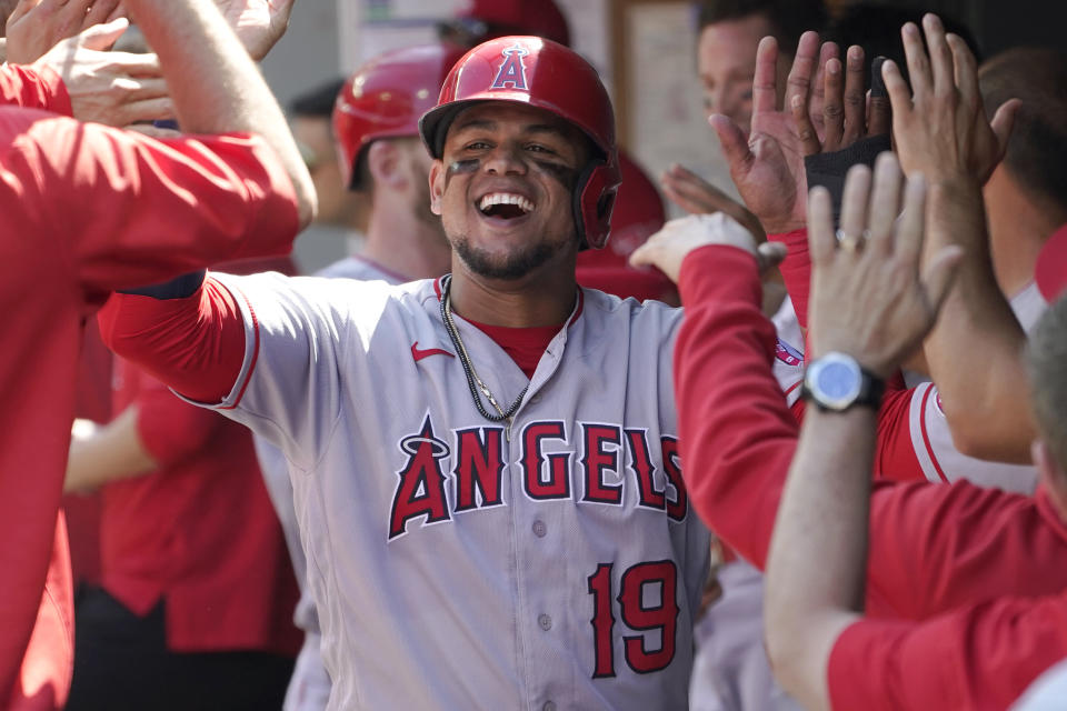 Los Angeles Angels' Juan Lagares is greeted in the dugout after he scored on a two-RBI single hit by David Fletcher during the fifth inning of a baseball game against the Seattle Mariners, Sunday, July 11, 2021, in Seattle. (AP Photo/Ted S. Warren)