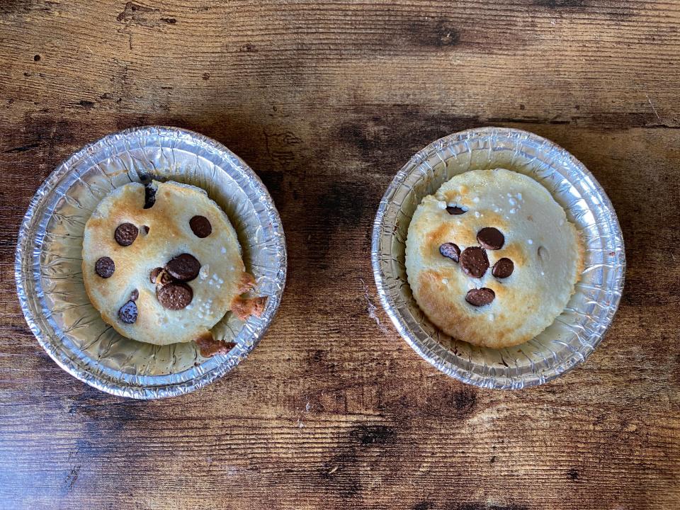 Two baked pancakes in tin cups on a table