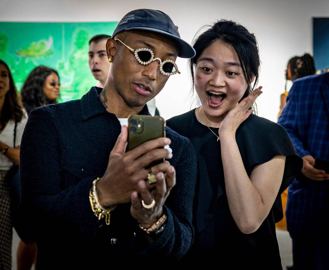 Musician Pharrell Williams, left, takes a selfie with a fan at the Art Basel VIP opening day in Miami Beach.