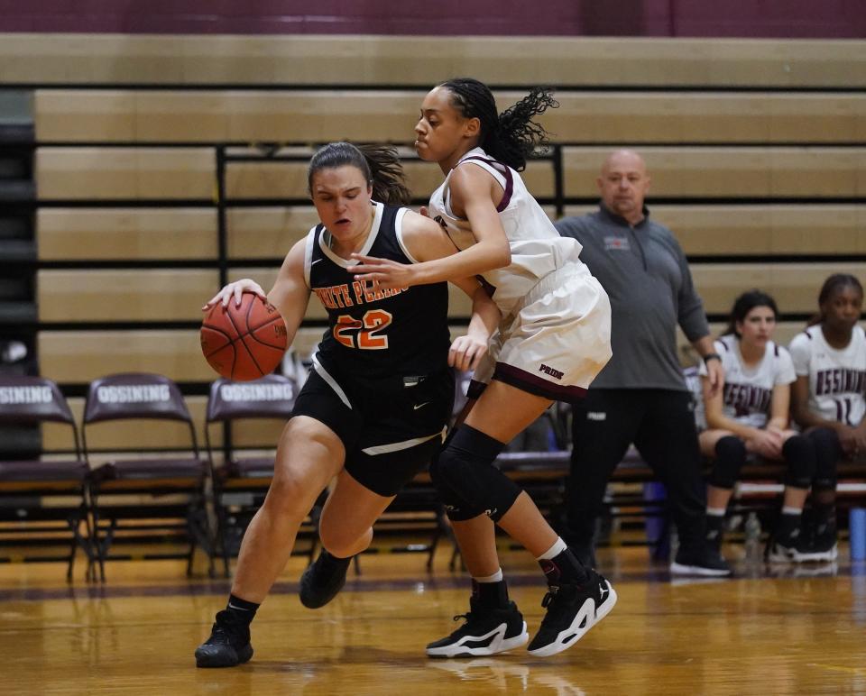 White Plains' Isabella McGuire (22) drives the baseline on Ossining's Saniya Bell (23) during girls basketball action at Ossining High School on Friday, Jan. 19, 2024.
