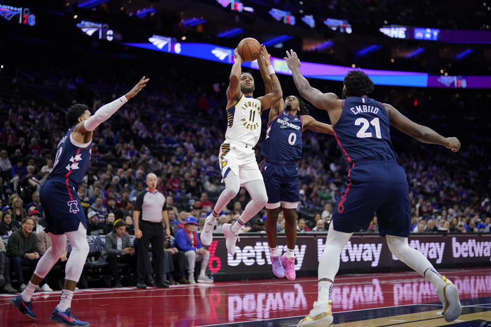 Indiana Pacers' Bruce Brown (11) tries to get a shot past Philadelphia 76ers' Tyrese Maxey (0), Joel Embiid (21) and Tobias Harris (12) during the first half of an NBA basketball in-season tournament game, Tuesday, Nov. 14, 2023, in Philadelphia. (AP Photo/Matt Slocum)