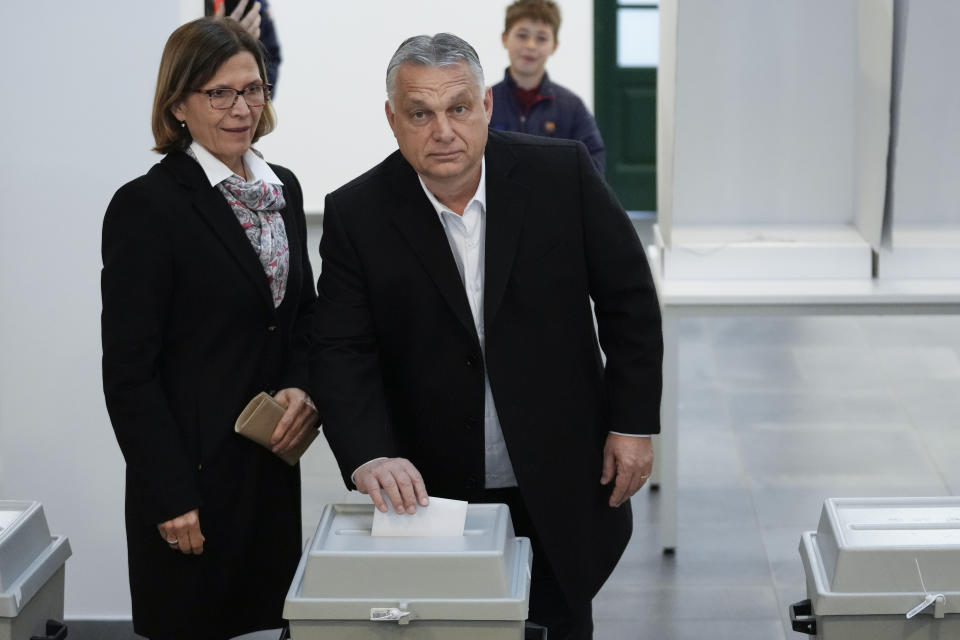 Hungary's nationalist prime minister, Viktor Orban, center, and his wife Aniko Levai, left, cast their vote for general election in Budapest, Hungary, Sunday, April 3, 2022. Orban seeks a fourth straight term in office, a coalition of opposition parties are framing the election as a referendum on Hungary's future in the West. (AP Photo/Petr David Josek)