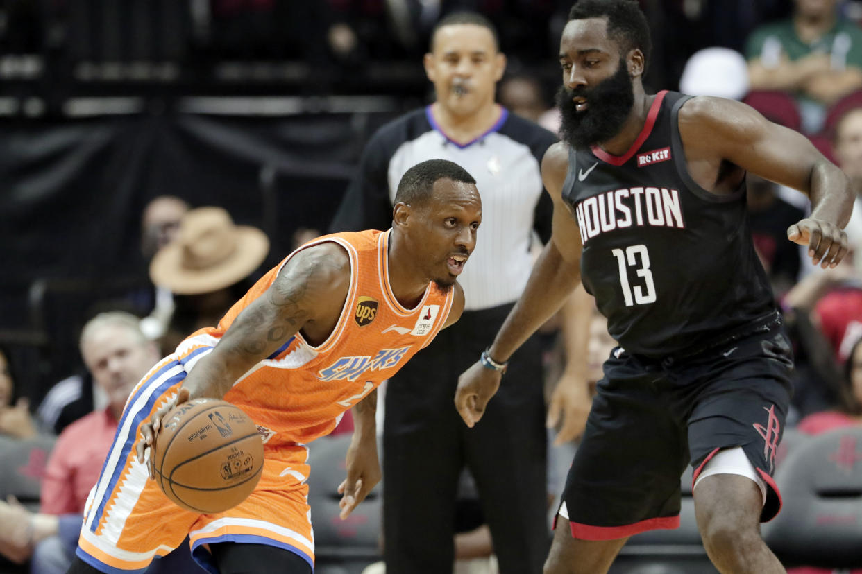 Shanghai Sharks forward James Nunnally, left, drives around Houston Rockets guard James Harden (13) during the second half of an NBA basketball preseason game Monday, Sept. 30, 2019, in Houston. (AP Photo/Michael Wyke)