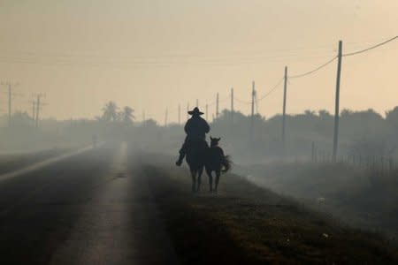 A man rides horseback along a road near Colon, Cuba, November 30, 2016. REUTERS/Ivan Alvarado