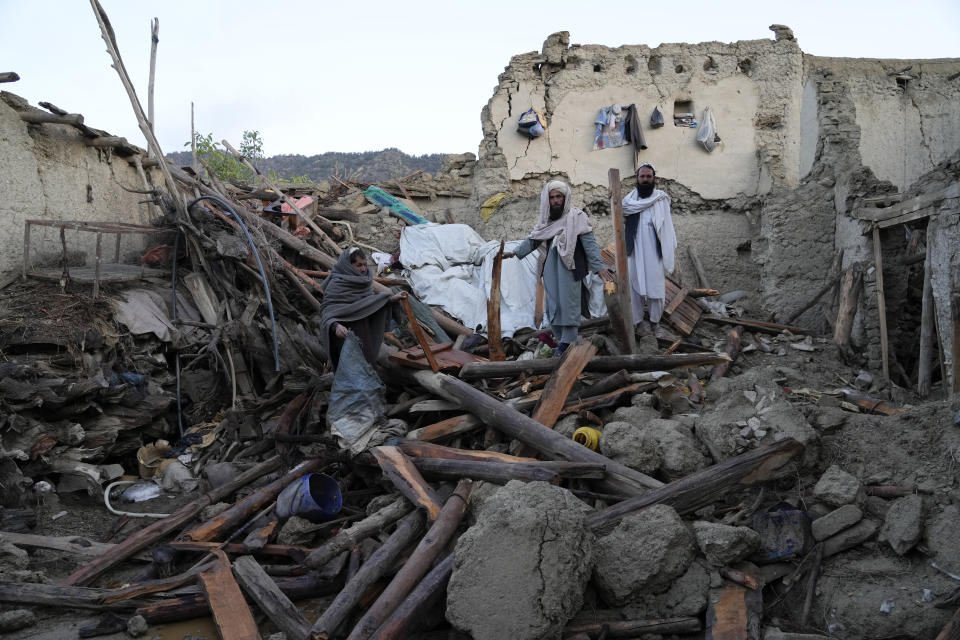 File - Afghans stand among destruction after an earthquake in Gayan village, in Paktika province, Afghanistan, Thursday, June 23, 2022. (AP Photo/Ebrahim Nooroozi, File)