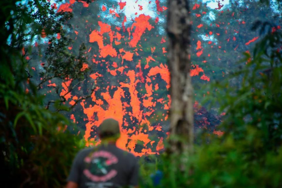 <p>A man watches as lava is seen coming from a fissure in Leilani Estates subdivision on Hawaii’s Big Island on May 4, 2018. Up to 10,000 people have been asked to leave their homes on Hawaii’s Big Island following the eruption of the Kilauea volcano that came after a series of recent earthquakes. (Photo from Frederic J. Brown/AFP/Getty Images) </p>