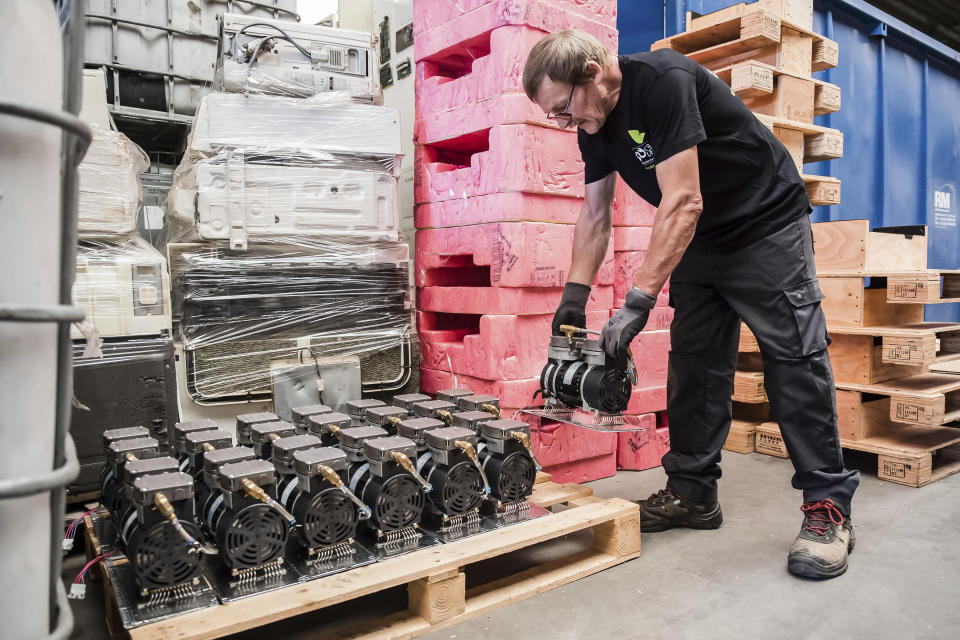 In this photo taken on July 13, 2018, a worker stacks components of an electronic element on a pallet at the Out Of Use company warehouse in Beringen, Belgium. European Union nations are expected to produce more than 12 million tons of electronic waste per year by 2020, putting the Out Of Use company at the front of an expanding market, recuperating raw materials from electronic waste. (AP Photo/Geert Vanden Wijngaert)