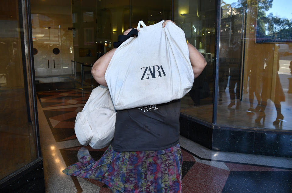 Elena Bobolas holds a bag over her face as she leaves the Downing Centre Local Court in Sydney on Tuesday.  Source: AAP Image.