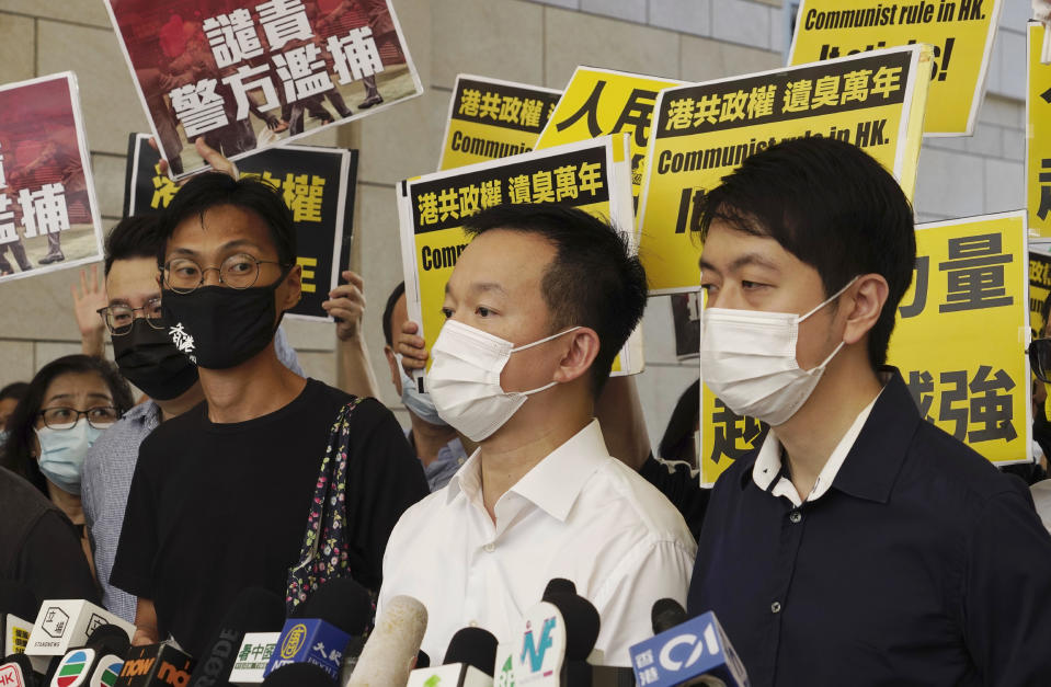 Pro-democracy lawmakers, from left, Eddie Chu, Raymond Chan and Ted Hui speak outside a local court in Hong Kong, Thursday, Nov. 19, 2020. Three former pro-democracy lawmakers appeared in court Thursday, one day after they were arrested for disrupting the legislature during debate on a national anthem bill earlier this year. (AP Photo/Vincent Yu)