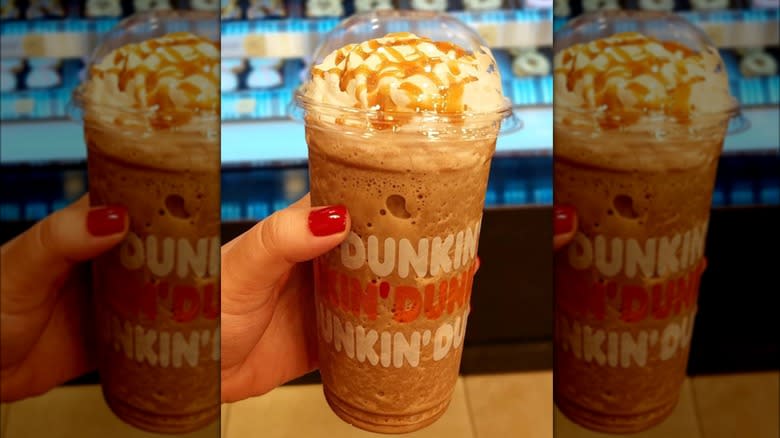 A hand holding a frozen Dunkin' Dunkaccino