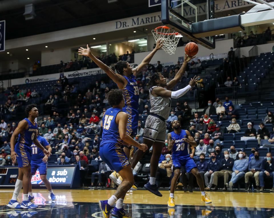 Monmouth's Myles Foster goes up against a pair of Hofstra defenders on Dec. 22, 2021 in West Long Branch.