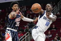 Dallas Mavericks forward Dorian Finney-Smith (10) passes the ball as Houston Rockets center Christian Wood (35) defends during the first half of an NBA basketball game Friday, Jan. 7, 2022, in Houston. (AP Photo/Eric Christian Smith)