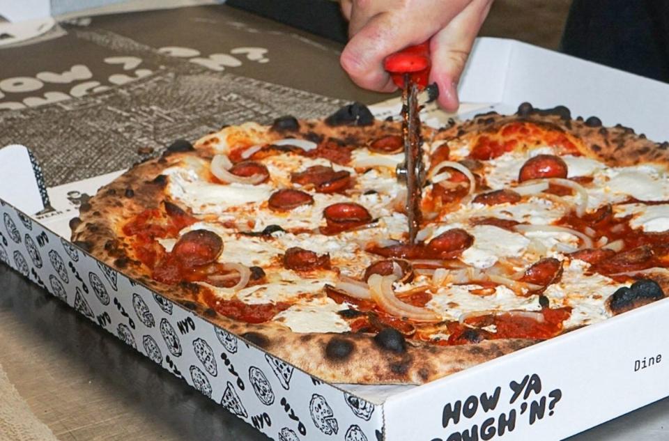 A pizza order, fresh from the wood-fire oven at How Ya Dough'n pizza shop in Boca Raton.