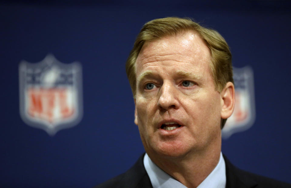 A tight shot of Roger Goodell's face in front of the NFL logo.