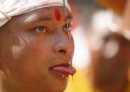 Jujubhai Bans Shrestha is pictured after getting his tongue pierced with an iron spike during the Tongue Penetration Festival at Bode near Kathmandu April 14, 2012. It is believed that after a volunteer from a Shrestha family successfully gets his tongue pierced in a spiritual trance with an iron spike and walks around the town shouldering a round bamboo rack with a flaming torch, it brings good fortune to the villagers. REUTERS/Navesh Chitrakar