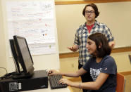 Coach J Collins watches Kaila Morris play "Heroes of the Storm," at Hathaway Brown School, Wednesday, July 10, 2019, in Shaker Heights, Ohio. Hathaway Brown launched the country's first varsity esports program at an all-girls school. Collins hopes to encourage more girls to stick with video games through their teenage years, something that might have a ripple effect across an industry grappling with gender disparity. (AP Photo/Tony Dejak)