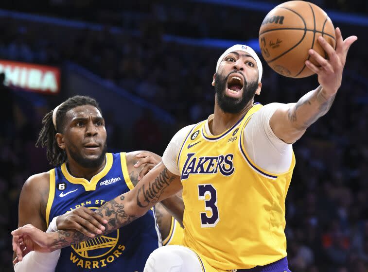 Los Angeles, CA - May 12: Los Angeles Lakers forward Anthony Davis, right, stretches to grab a rebound against Golden State Warriors forward Kevon Looney during the first half of the NBA Playoffs Western Conference semifinals at Crypto.com Arena on Friday, May 12, 2023 in Los Angeles, CA.(Wally Skalij / Los Angeles Times)