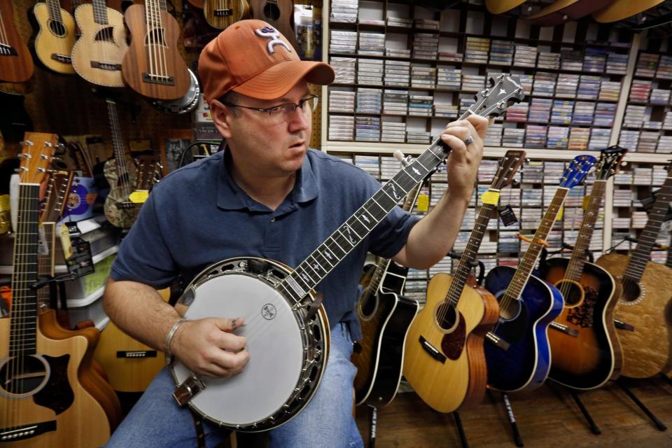 Eric Seamen getting his truss rod adjusted on his 5-string banjo at Bluegrass Musicians Supply in this 2014 file photo.